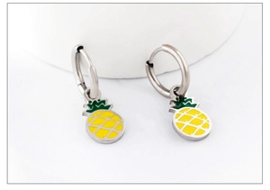 Close-up of silver earrings with yellow and green enamel pineapple pendants