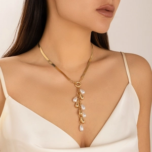 Baroque style gold snake chain necklace with pearl tassel fringe on a female model
