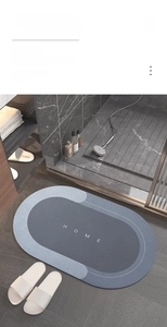 Detail of absorbent anti-slip bathroom mat with Home text and sleek modern design