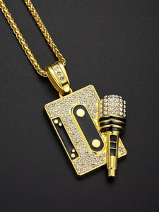 Macro shot of gold-plated hip hop cassette and microphone pendant with shiny rhinestones