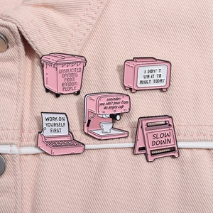 Pink cartoon enamel pins set featuring typewriter and coffee machine on denim jacket