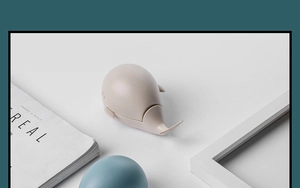 Detail shot of a cute beige whale-shaped laundry brush on a minimalist white tabletop