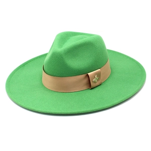 Detail of bright green wool fedora with khaki ribbon and golden bee ornament