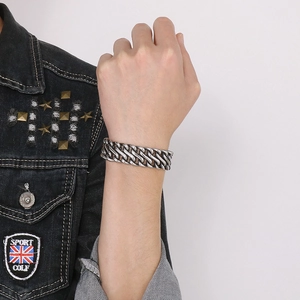 Detail of multi-layer woven stainless steel biker bracelet on wrist for men