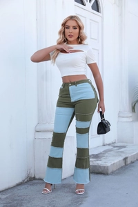 Détail d'un jean évasé taille haute avec empiècements contrastés denim et vert olive