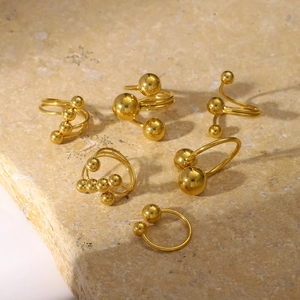 Bagues minimalistes en acier titane doré avec sphères géométriques sur base en pierre