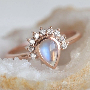 Macro shot of pear-shaped moonstone ring with diamond crown set in rose gold finish