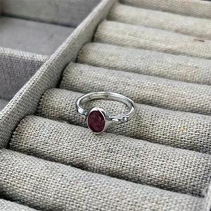 Close-up of 925 sterling silver ring with oval purple gemstone and organic texture