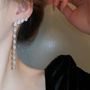 Eleganti orecchini pendenti in argento con zirconi a goccia indossati dalla modella di profilo