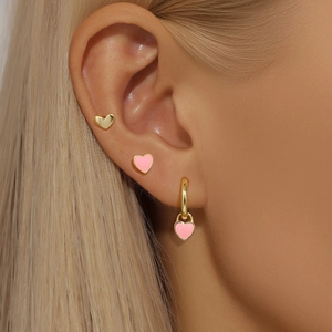 Close-up of S925 silver heart stud earrings and pink enamel hoop worn by model