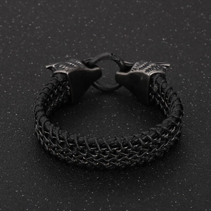 Close-up of dual viking wolf heads clasp on black braided leather bracelet for men