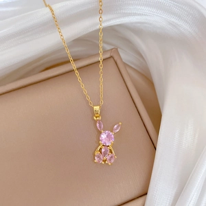 Pink crystal rabbit pendant necklace in gold finish displayed on a luxury jewelry box