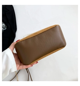 Detailed view of the brown leather base and suede trim of this retro bucket bag
