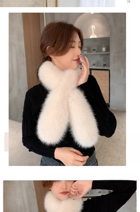 Detailed macro view of plush cross-style faux fox fur scarf in soft cream white color