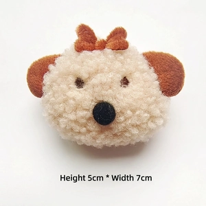 Detail of plush cream bear accessory with bow, measuring 5cm in height and 7cm in width