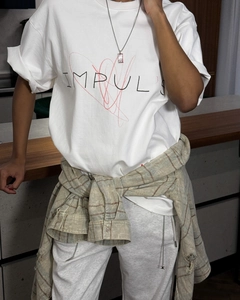 Détail d'un t-shirt blanc en coton avec imprimé IMPULSE et design de graffiti coeur rouge