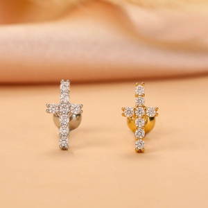 Close-up of gold and silver cross stud earrings with sparkling cubic zirconia inlay