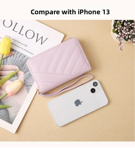 Close-up of pink quilted leather wallet with wristlet and zipper on desk background