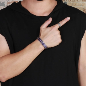 Detail of colorful dragon bone chain bracelet and silver ring on male model hand