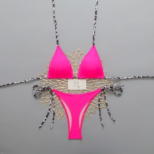 Detail of neon pink bikini with leopard print ties and decorative gold floral accents