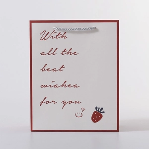 Detailed view of white gift bag with red strawberry graphics and grey rope handle