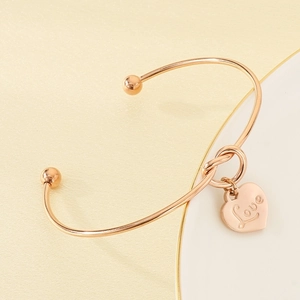 Detailansicht eines 18K vergoldeten Armreifs mit herzförmigem Love-Anhänger-Detail