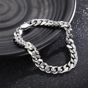Close-up of silver titanium steel Cuban link bracelet with lobster clasp on black background