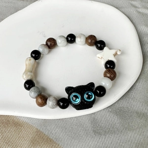 Detailansicht eines Keramikperlen-Armbands mit schwarzer Katze und weißem Sternanhänger