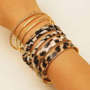 Close-up of bohemian layered bracelets with leopard print leather and sparkling crystals