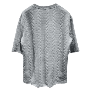 Détail d'un t-shirt en tricot gris pour homme avec texture à mailles torsadées