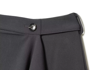 Detail view of charcoal gray woven fabric trousers with button and belt loop features