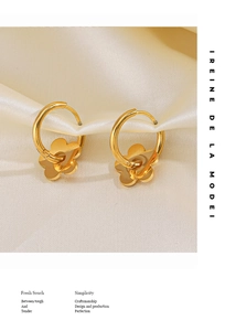 Détail de boucles d'oreilles fleurs plaquées or 18K sur fond de soie blanche