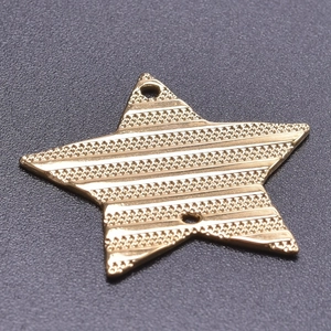 Macro shot of a gold star charm pendant with textured finish and dual connection holes