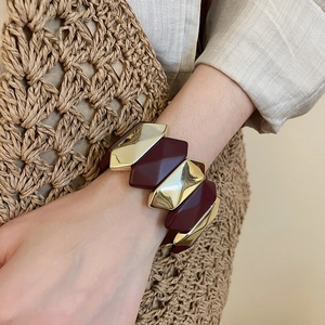 Detail of burgundy and gold geometric moon bracelet worn on wrist for a boho vacation look