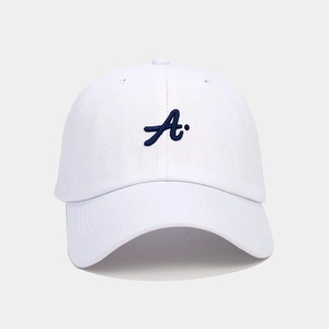 Close-up of a white cotton baseball cap with deep blue letter A 3D embroidery detail