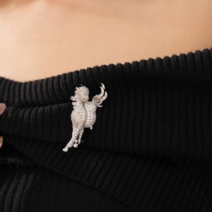 Close-up of flying dragon brooch with cubic zirconia on black knit sweater