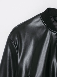 Close-up of black leather jacket showing ribbed neckline and premium texture detail