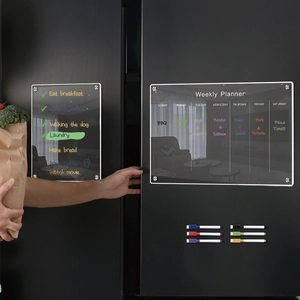 Close-up of magnetic acrylic weekly planner and list board with 6 markers on a black fridge