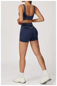 Detail view of high waist navy blue yoga shorts with white contrast stitching and heart seam