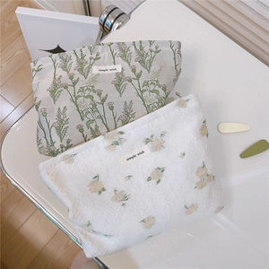 Close-up of floral fabric toiletry bags in green and yellow with simple wish labels