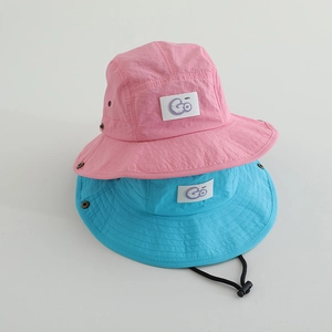 Gros plan de chapeaux de soleil roses et bleus pour enfants avec broderie Go et cordons