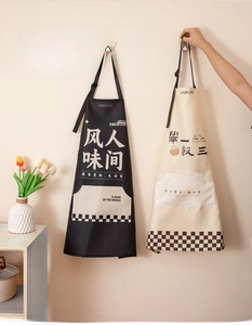 Detail of waterproof kitchen aprons in black and beige with adjustable neck straps