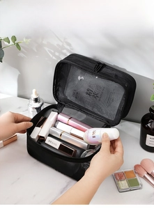 Detail view of large capacity mesh cosmetic bag with multiple skincare compartments