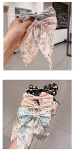 Detail of floral bow hair clips with long ribbons in pastel blue, pink and beige