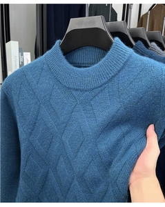 Detailopname van de blauwe gebreide trui met 3D-ruitpatroon en zachte textuur