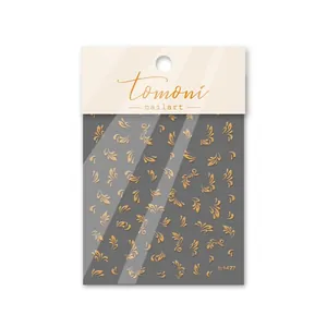 Details von goldfarbenen Nagelaufklebern mit Blumenmustern und Markenverpackung