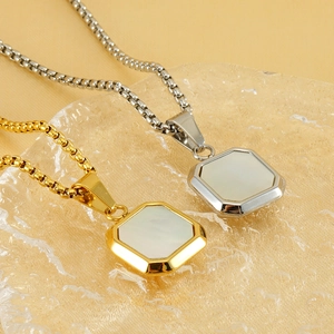 Gros plan de pendentifs octogonaux en or et argent avec incrustation de nacre sur verre