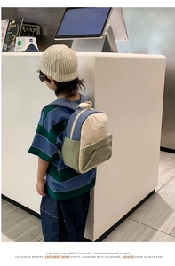 Kid back view of a color-blocked canvas backpack for toddlers on a boy in a store
