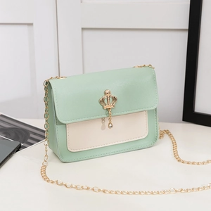 Chic mint green and cream crossbody bag with a gold crown pendant and chain strap