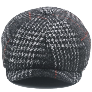 Close-up of wool blend newsboy cap with classic black grey houndstooth pattern and red checks